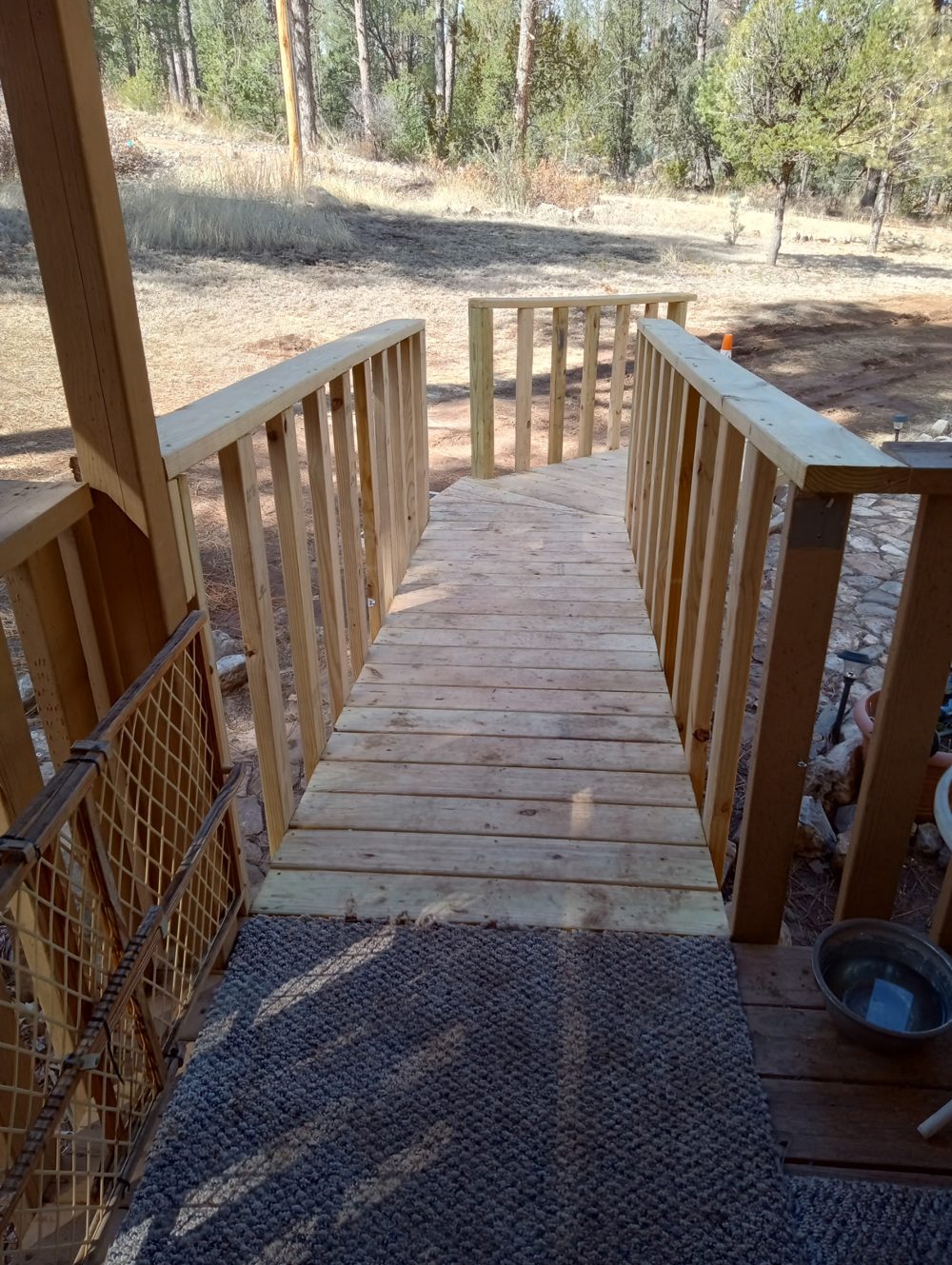 View down the same ramp from the porch, showing the turn and both handrails